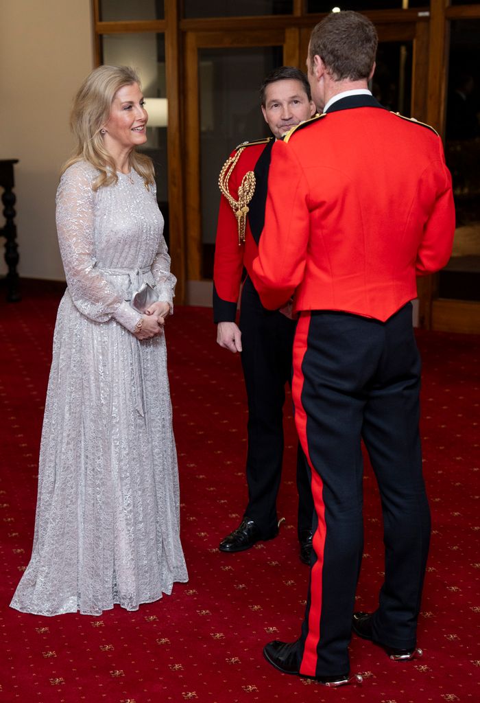 Sophie talking to two men in army dress uniform