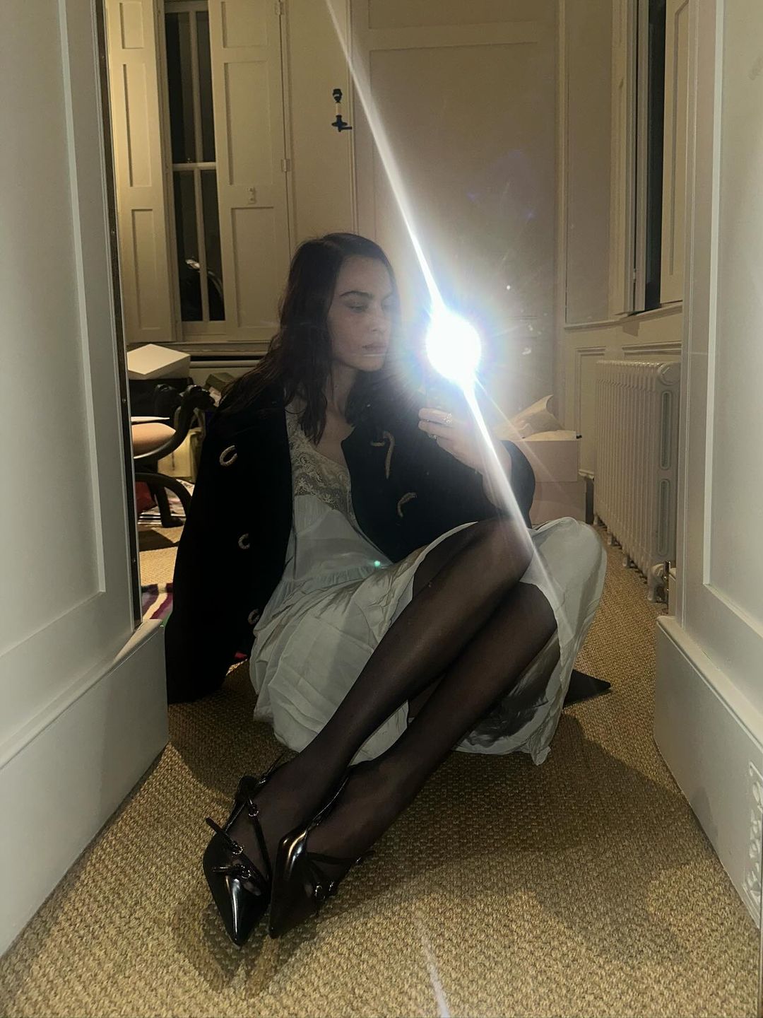 Alexa Chung poses in a night dress and sheer tights on her Instagram