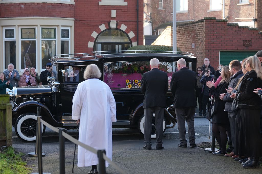 Mourners applaud as the coffin arrives for the funeral of Linda Nolan 