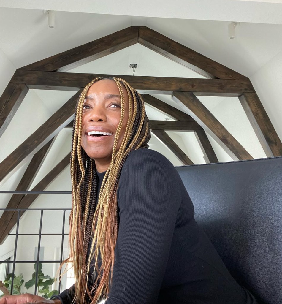 heather headley smiling in coach house with wooden beams 