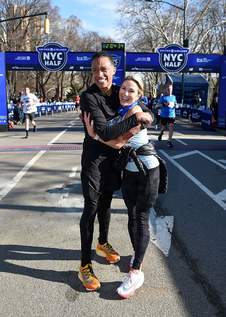 TJ Holmes and Amy Robach celebrate as they cross the finish line during the 2022 United Airlines NYC Half Marathon on March 20, 2022 