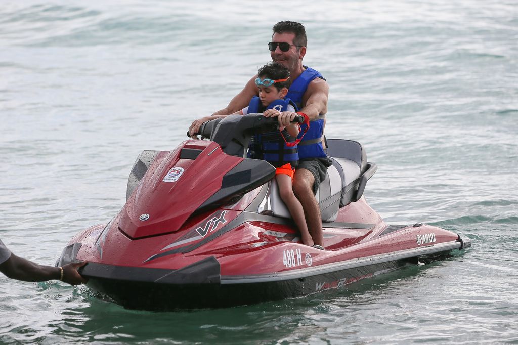 Simon Cowell and his son riding a jetski