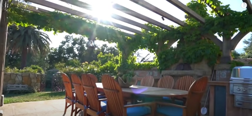 outdoor dining space with pergola and barbecue in the sunshine 