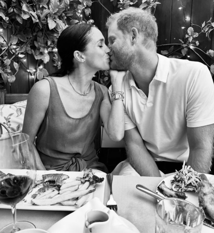 Meghan Markle and Prince Harry kissing at a meal