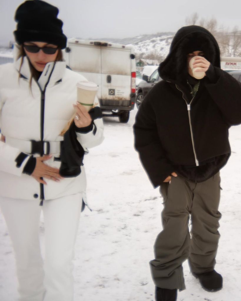 Hailey and Justin holding coffee cups while walking to the slopes in Aspen