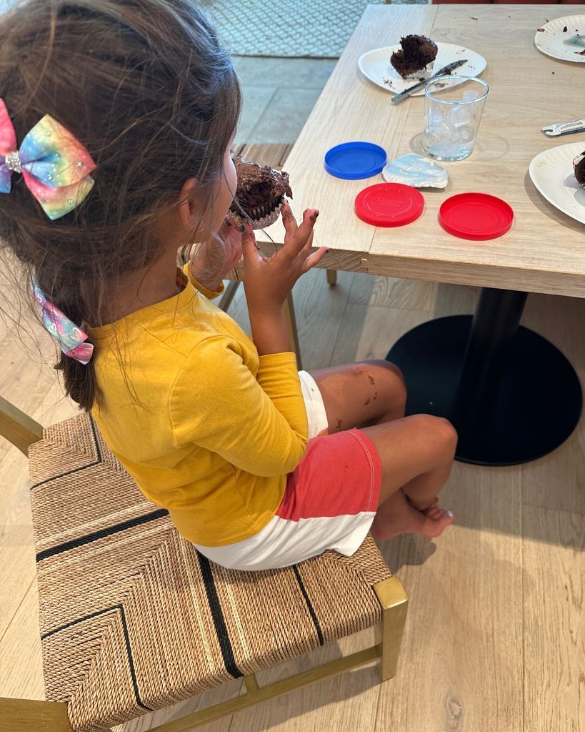 mindy kaling daughter katherine sitting at table eating cupcake