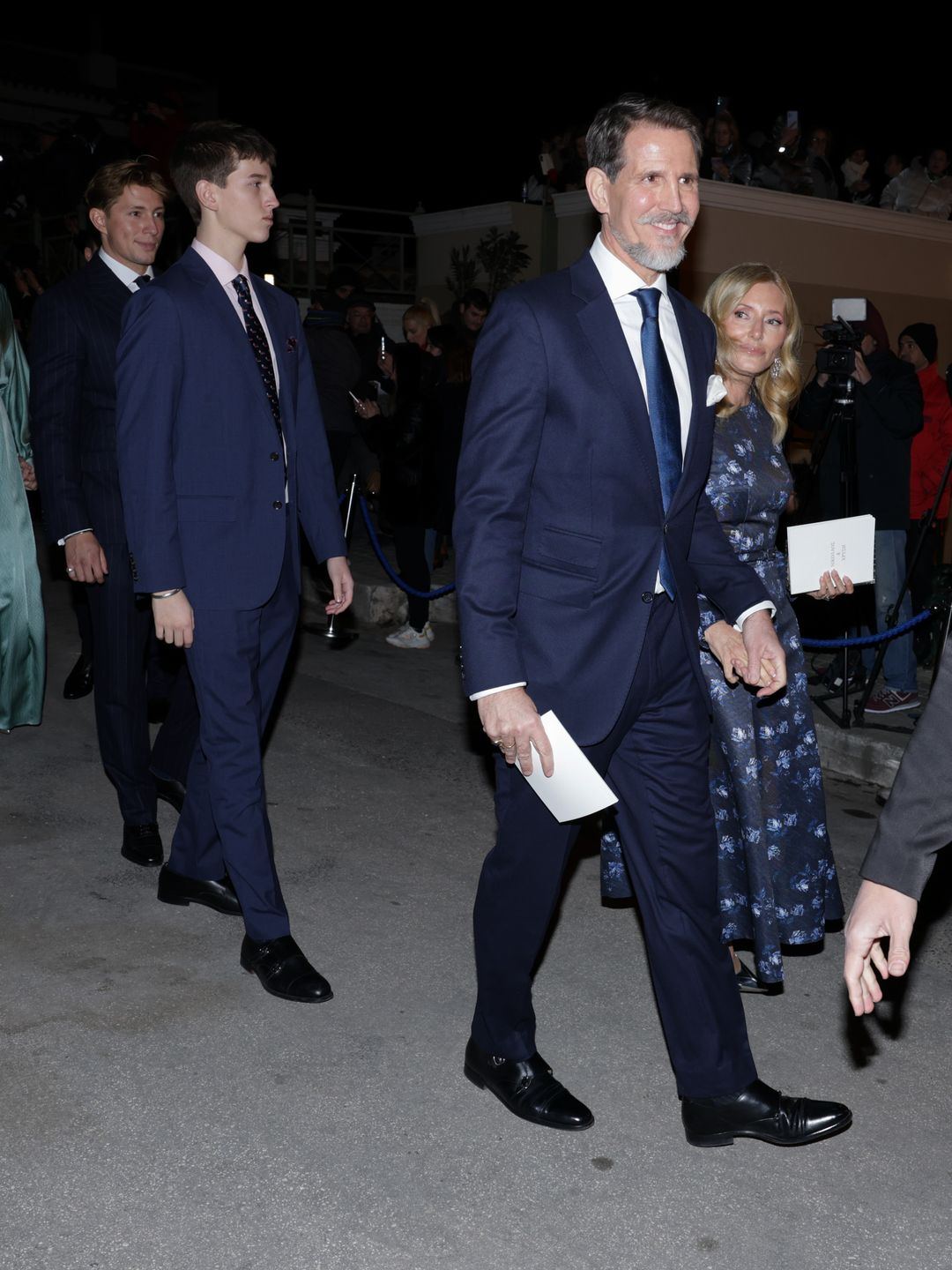 Crown Prince Pavlos, Crown Princess Marie-Chantal and two of their sons walking down a street