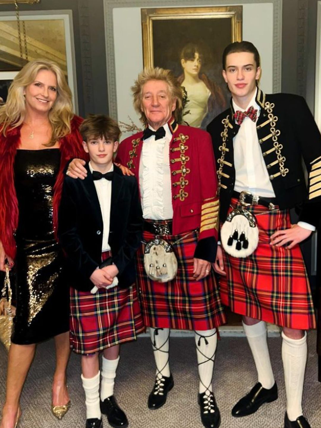 Penny Lancaster standing with Aiden Stewart, Rod Stewart and Alastair Stewart with the men in kilts