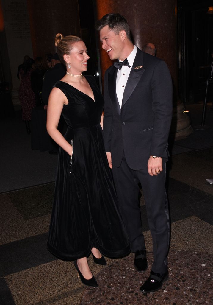 Scarlett Johansson and Colin Jost smiling and laughing in black clothes