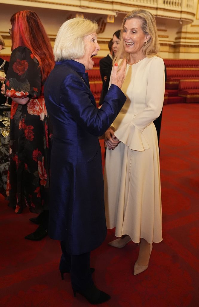 Duchess of Edinburgh in a white dress laughing with Tessa Munt 