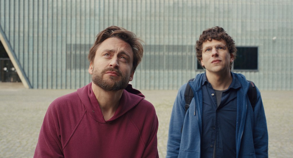 Still of Kieran Culkin and Jesse Eisenberg filming a scene looking up at the sky in A Real Pain