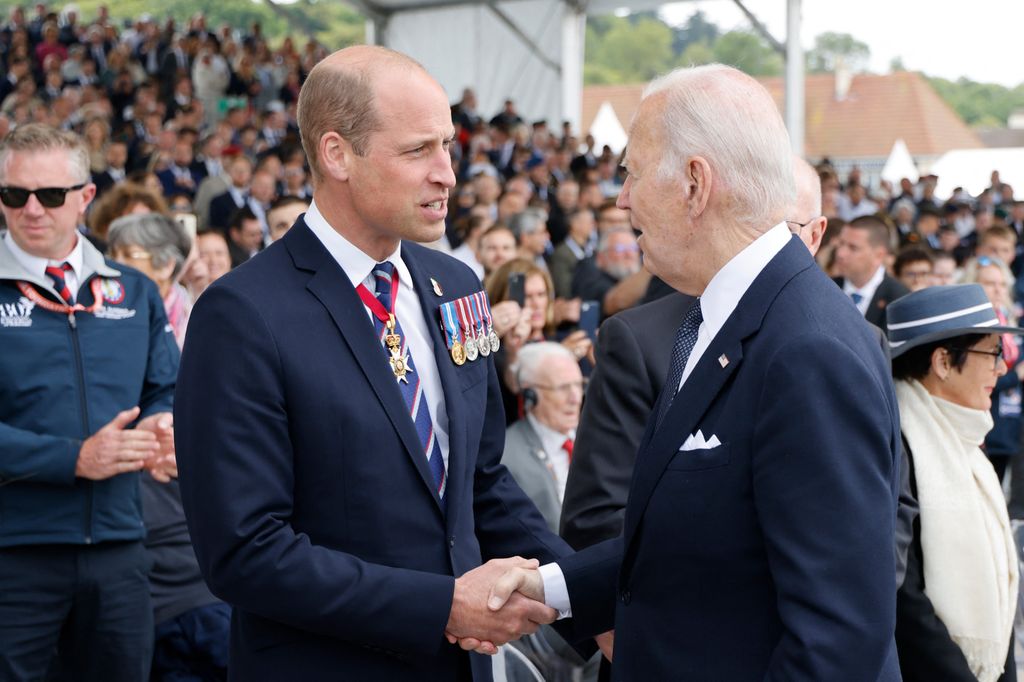 Britain's Prince William, the Prince of Wales (L) shakes hand with US President Joe Biden