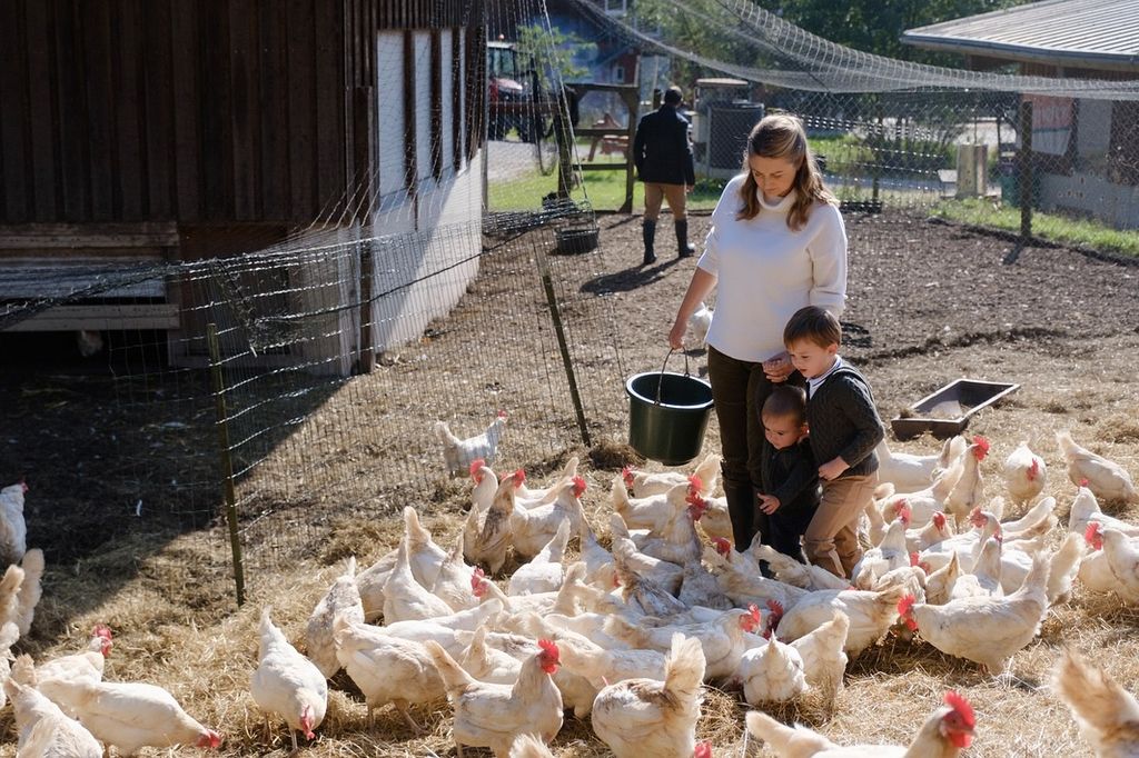 Princess Stephanie and her sons feeding chickens