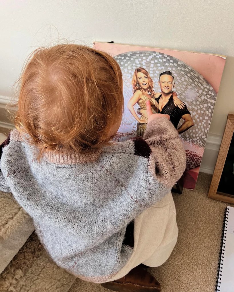 Minnie Dooley points at her mum and dad on a Strictly Come Dancing poster