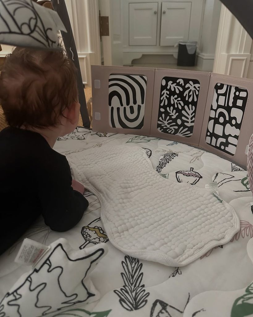 Photo of baby Ford lying on a play mat looking at toys