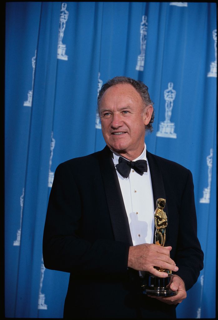 Gene Hackman holding his Oscar in 1993 in front of blue screen