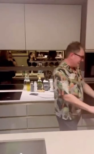 Alan Carr laughing in his kitchen with the oven in the background