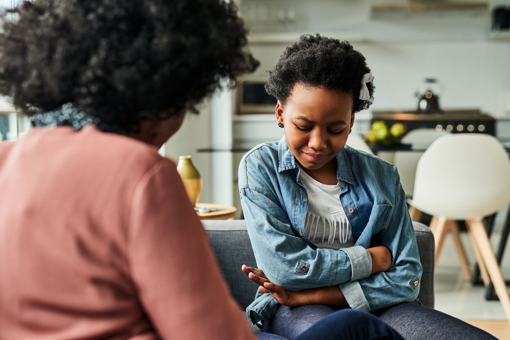 young girl looking upset while talking to her mother