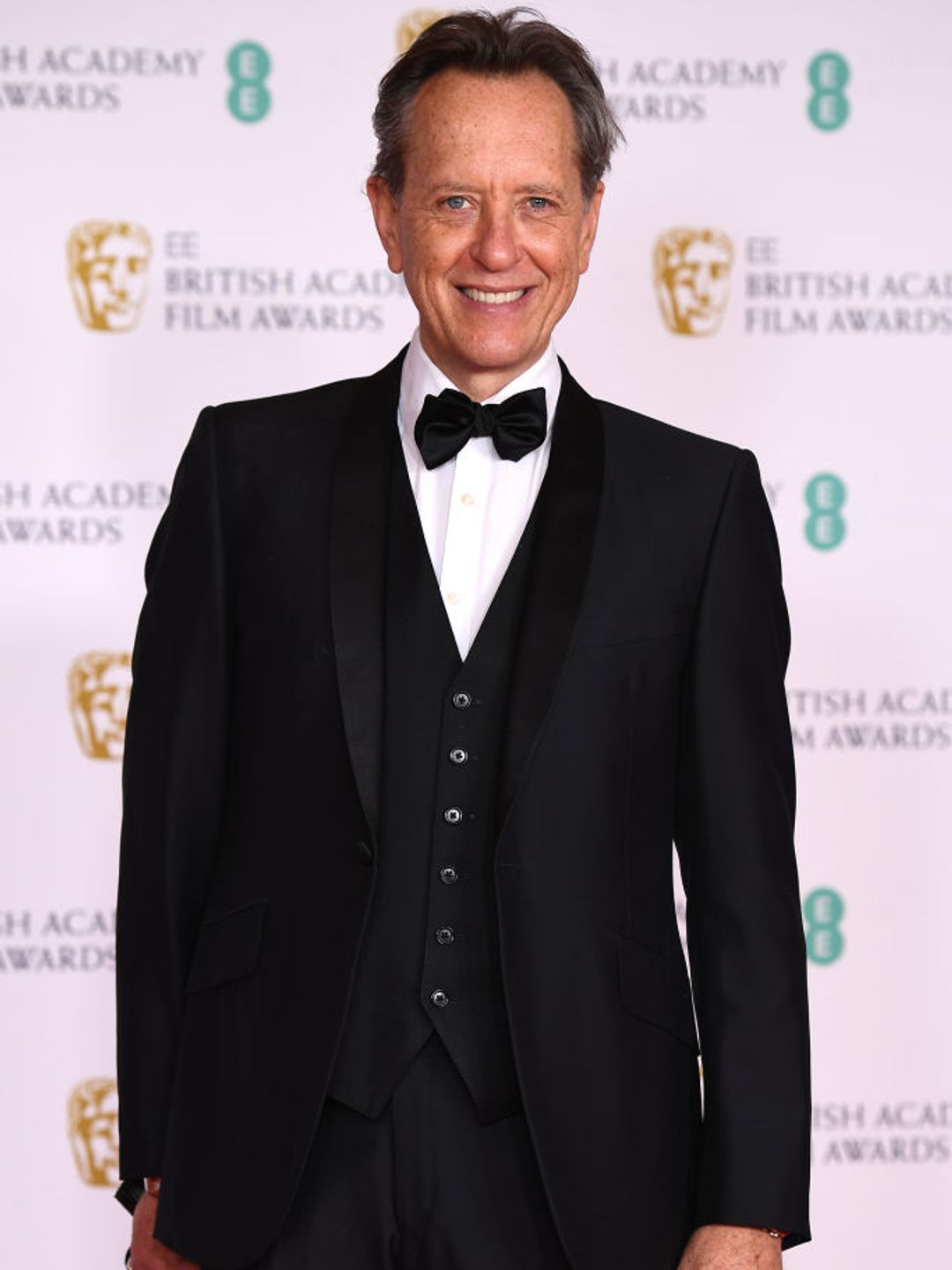 Richard E. Grant wearing a tux at the BAFTAs