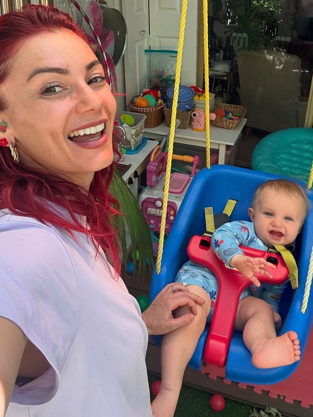 Dianne Buswell pushing her niece on a swing wearing a ring