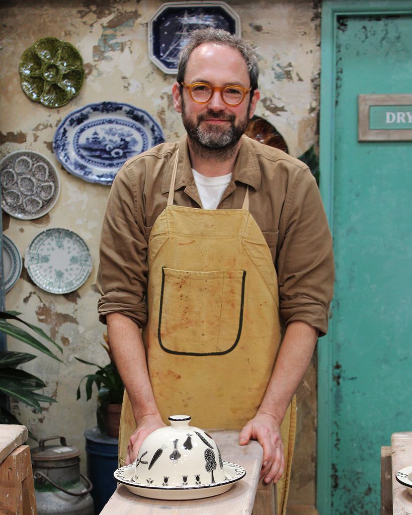 Man in apron in front of ceramic bowl