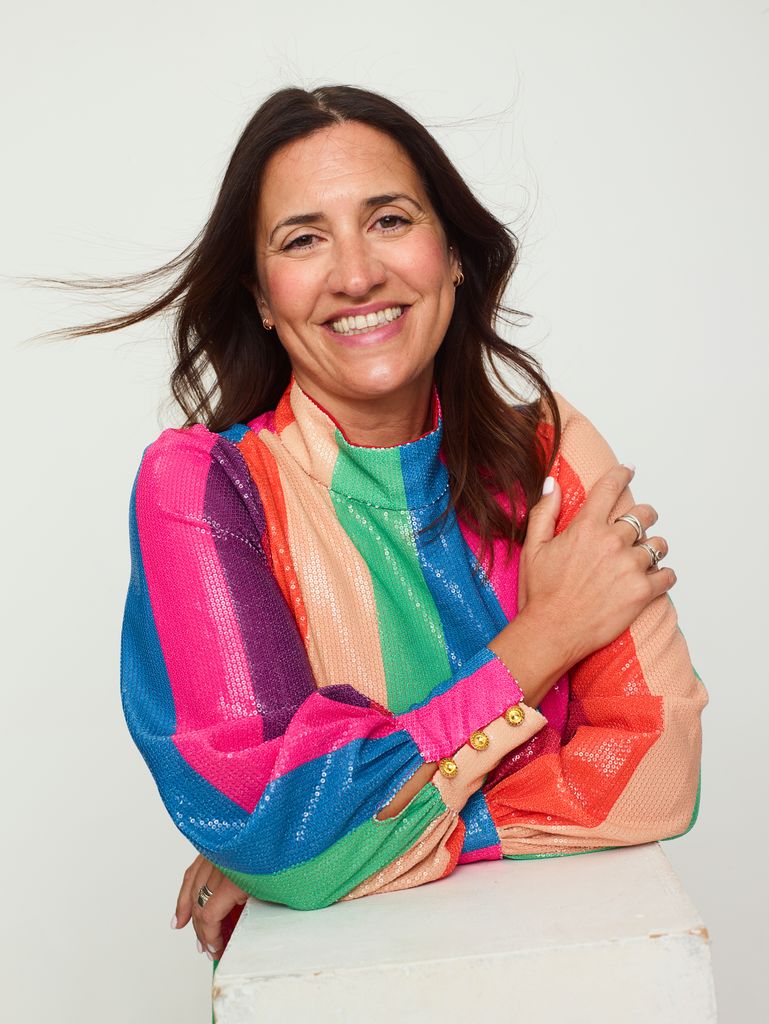 Donna Francis smiling in a rainbow top 