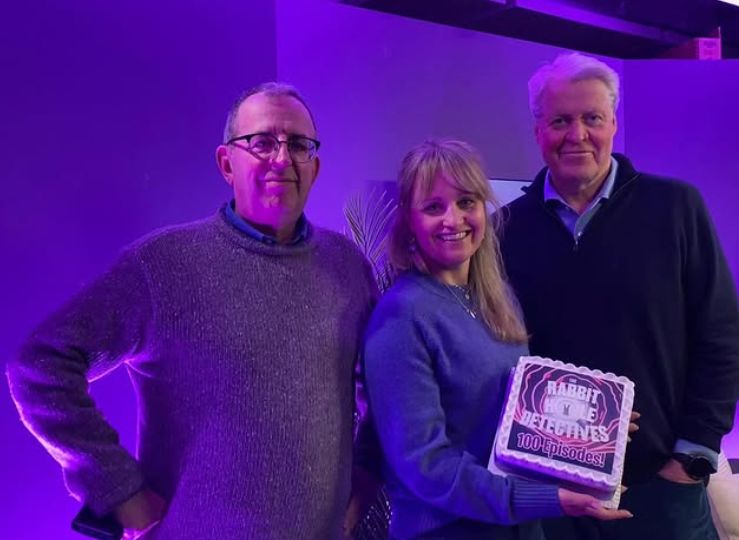 Rev. Richard Coles posing with Cat Jarman, who's holding a cake, and Charles Spencer