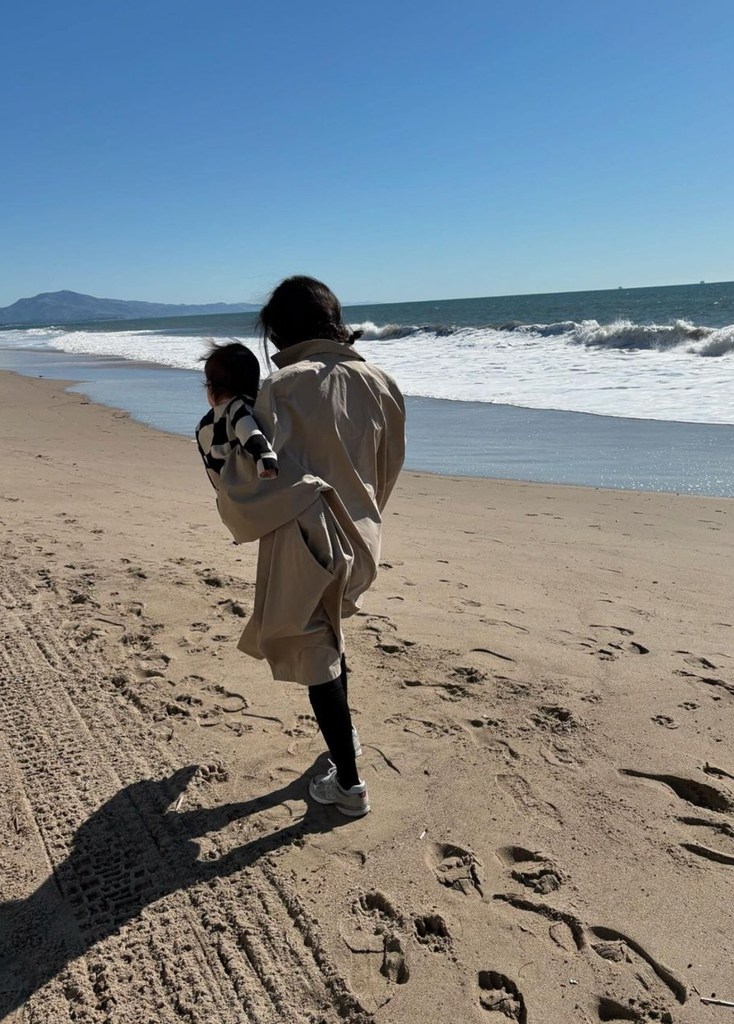 Photo shared by Kourtney Kardashian on Instagram November 2024 of her with her son Rocky walking on the beach