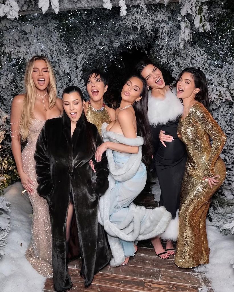 Khloe Kardashian, Kourtney Kardashian, Kris Jenner, Kim Kardashian , Kendall Jenner, and Kylie Jenner poses in front of a Christmas scene