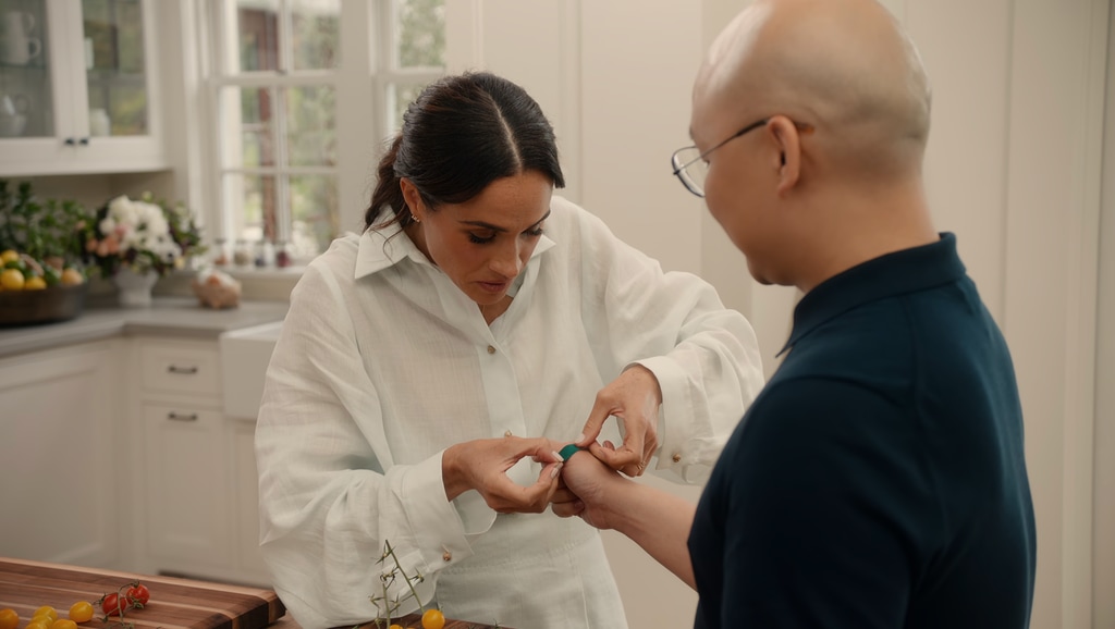 A photo of Meghan Markle putting a plaster on her friend Daniel's hand