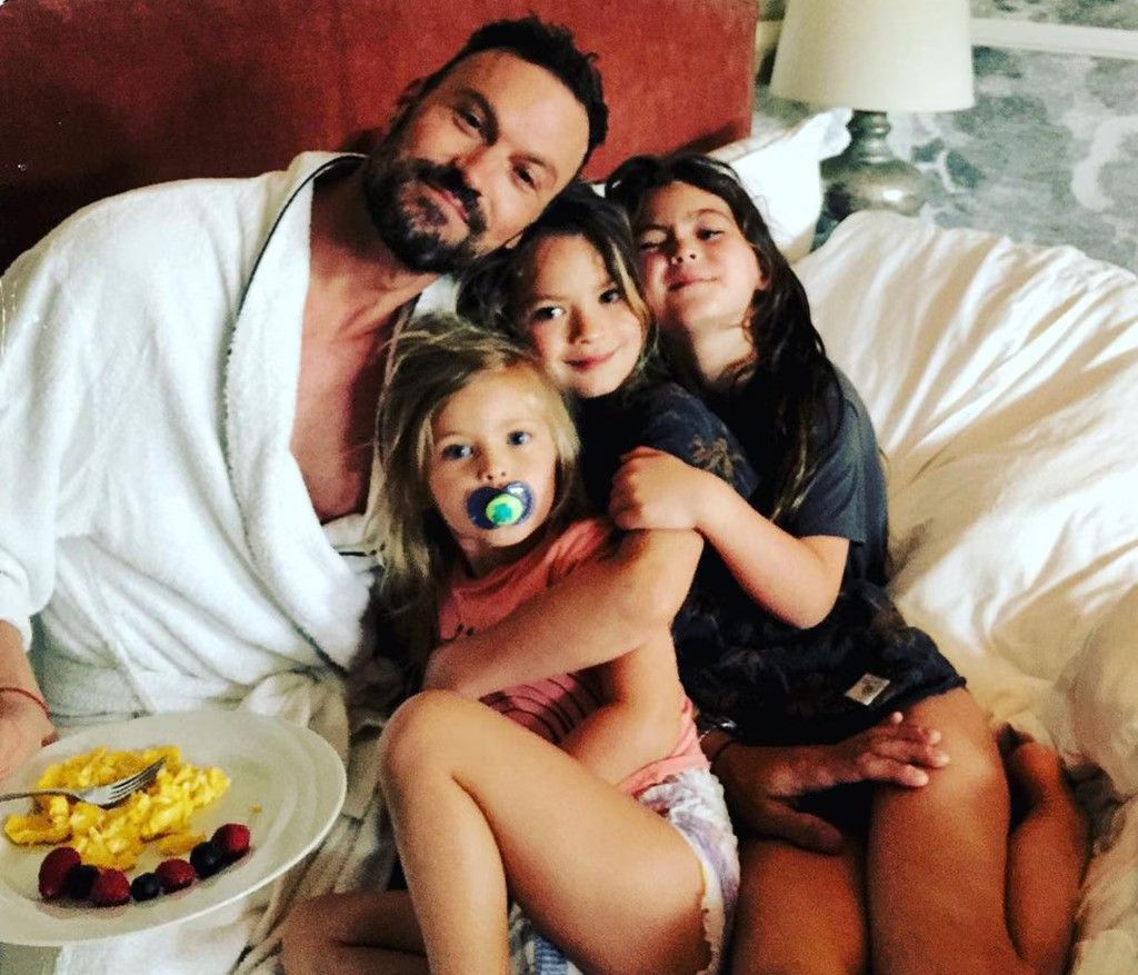 brian austin green on a bed with his 3 kids