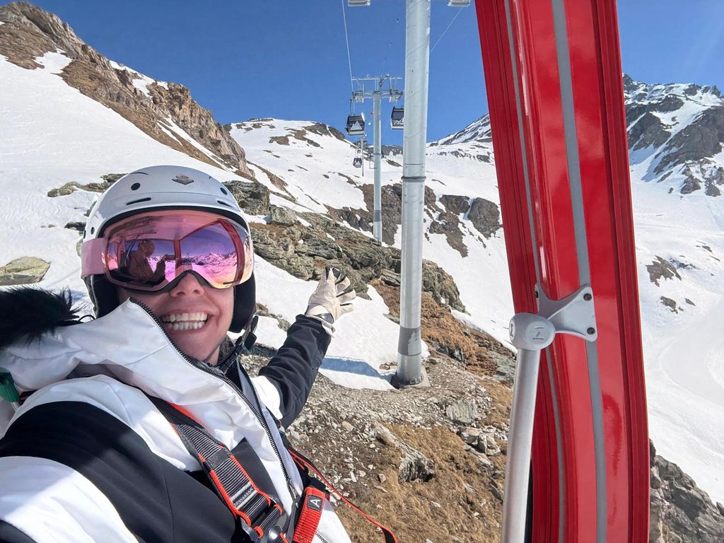 A woman on a ski lift dressed in ski gear