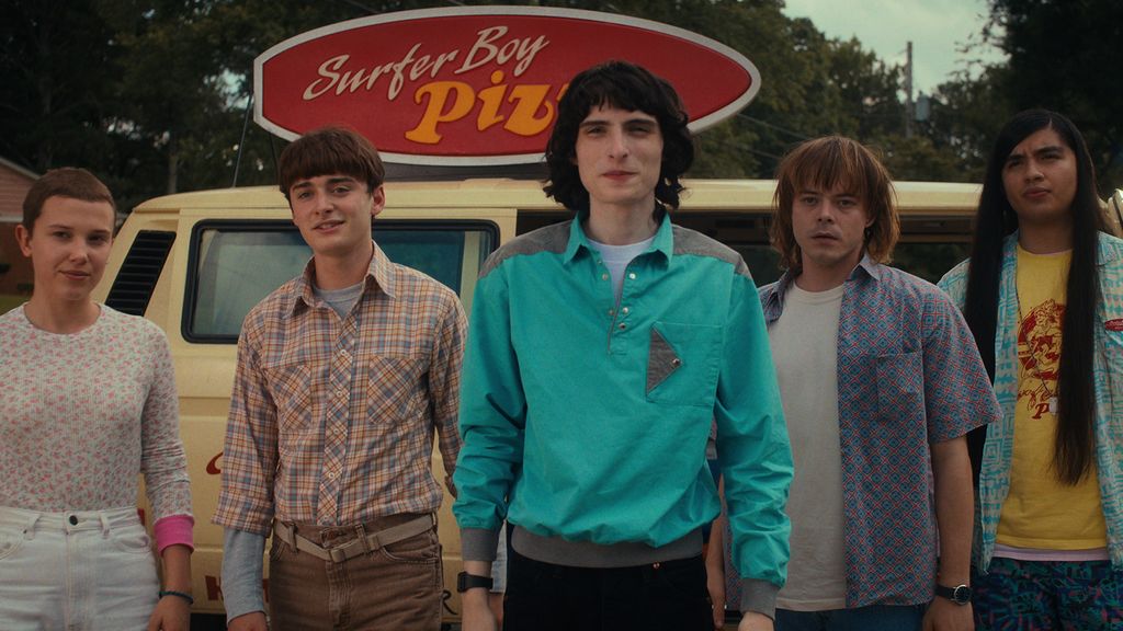 Mike, Eleven, Will and Jonathan standing in front of the Surfer Boy Pizza van. Stranger Things