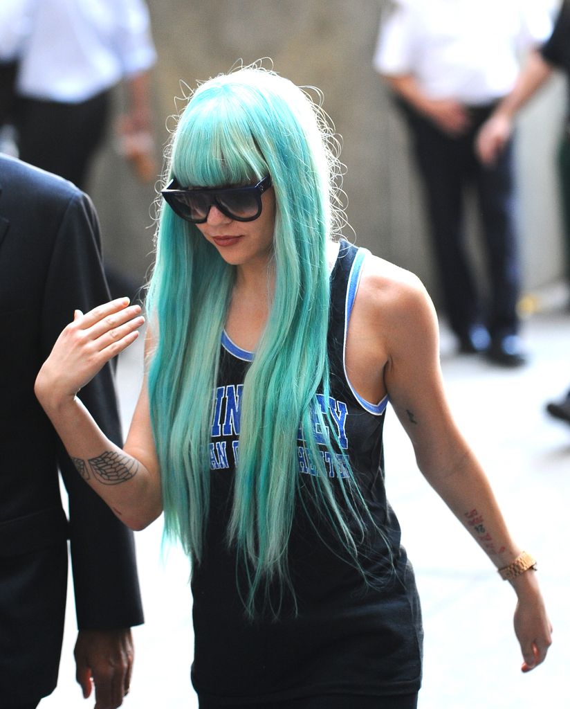 Actress Amanda Bynes with blue hair wearing sunglasses