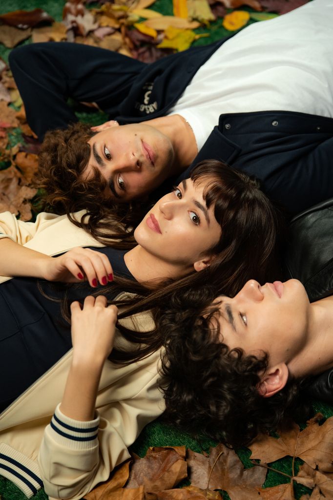 three people lying on grass