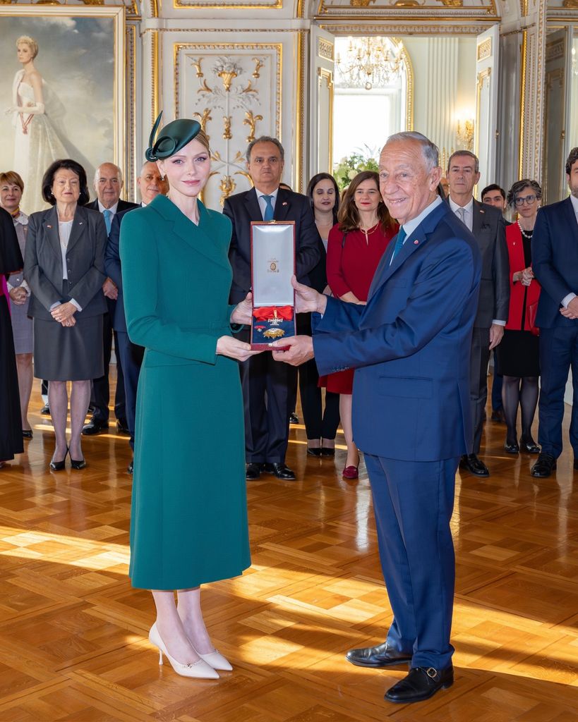 Charlene handing president of portugal a medal