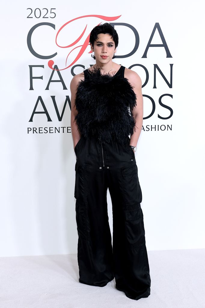 : BJ Pascual attends the 2025 CFDA Awards and poses on the red carpet in a feathered top and wide leg trouers