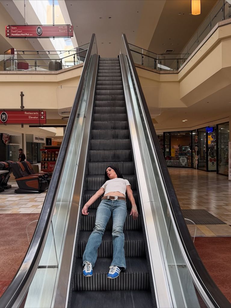 Katy Perry lays on an escalator while filming the "bandaids" music video, shared on Instagram