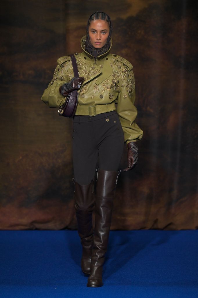 Model in leather boots and green jacket during Burberry autumn/winter 2025 