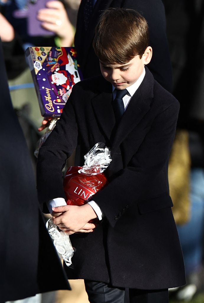 TOPSHOT - Britain's Prince Louis of Wales and Britain's Prince George of Wales hold chocolate received from well-wishers after attending the Royal Family's traditional Christmas Day service at St Mary Magdalene Church on the Sandringham Estate in eastern England, on December 25, 2025. (Photo by Henry NICHOLLS / AFP via Getty Images)