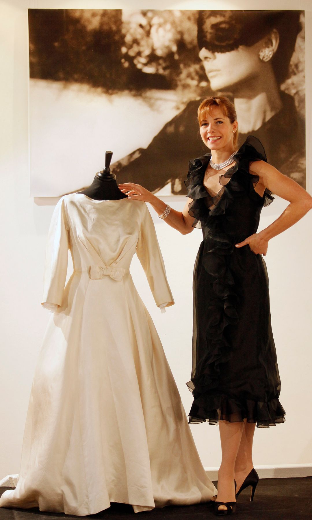 British former ballet dancer Darcey Bussell dressed in a Valentino haute couture black organza ruffle-edged cocktail gown dated 1970-71 and valued at GBP 4,000-6,000 (dollars 6,600-9,900 or euros 4,430- 6,650) poses with film star Audrey Hepburn's ivory satin wedding gown dated 1952 and valued at GBP 8,000-12,000 (dollars 13,200-19,800 or euros 8,860-13,300) during a photocall in central London, on December 7, 2009. Around 36 items of Audrey Hepburn's clothing including hats, belts and personal letters dating from 1953 to the 1960s will be auctioned on December 8, 2009 at La Galleria in Pall Mall in central London.