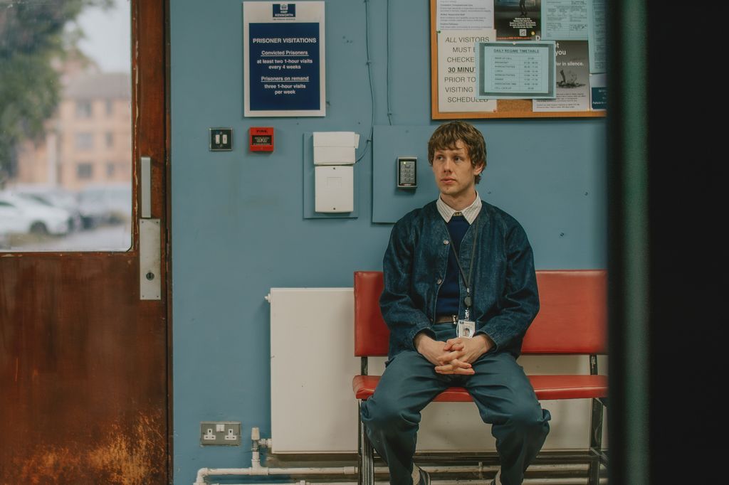 Josh Finan sitting inside a prison in a scene from Waiting for the Out