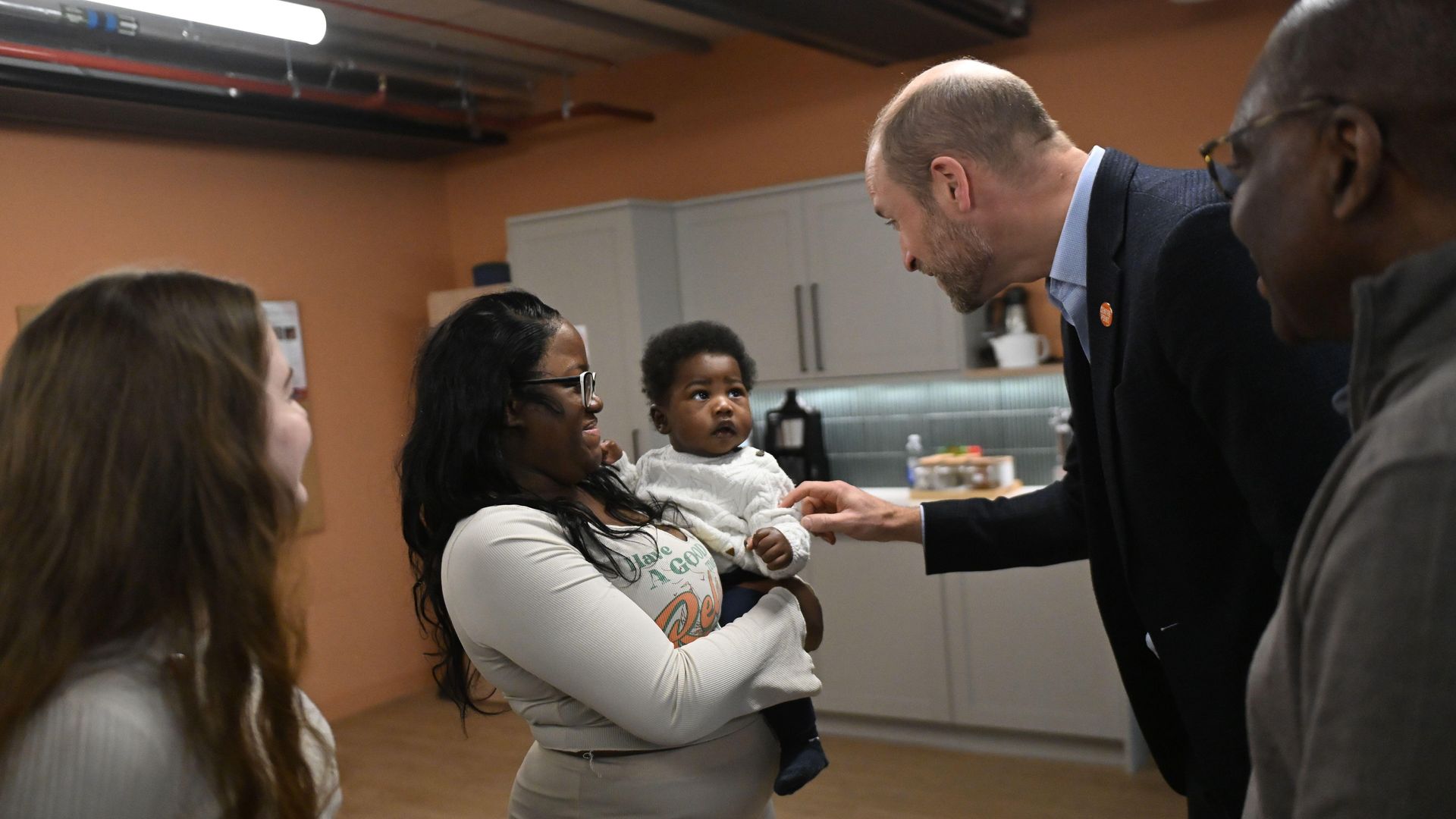 Prince William meeting a mother carrying a baby