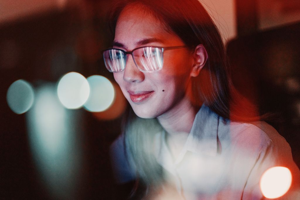 Close-up of a woman with eyeglasses looking at the computer