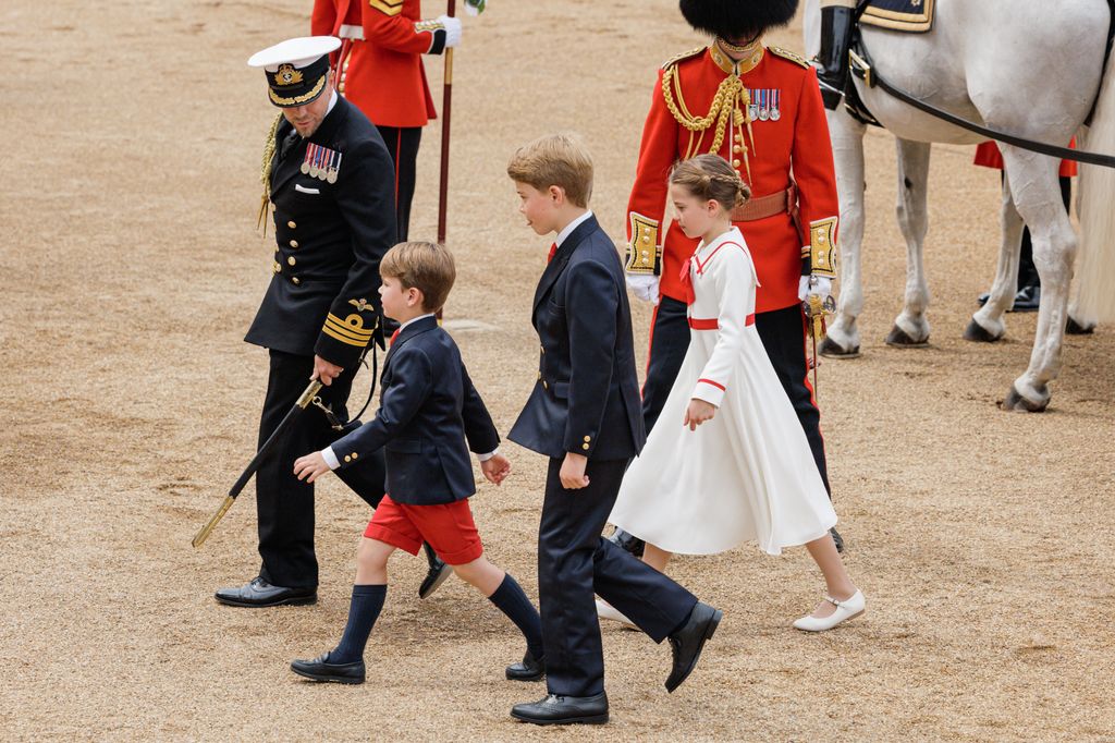 Prince George of Wales, Princess Charlotte of Wales and Prince Louis of Wales walk from a horse drawn carriage during Trooping the Colour in 2023