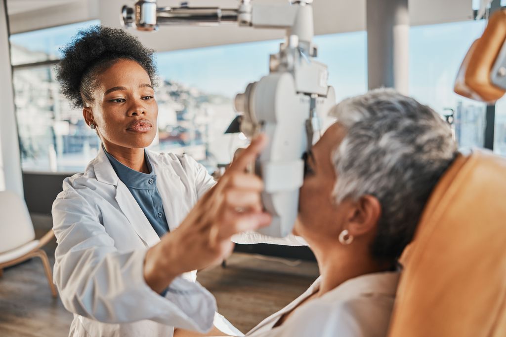 young woman doctor giving older woman an eye exam