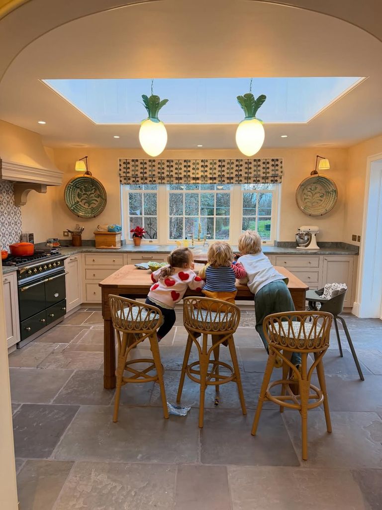 Romy, Frank and Wilfred, five, are pictured in the kitchen of the family's Oxfordshire manor house