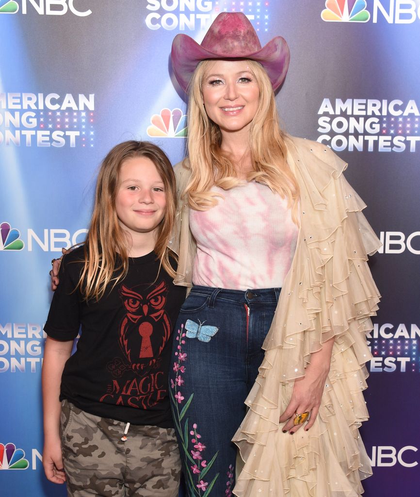  Kase Townes Murray in black top and cargo pants and mom Jewel  in pink cowboy hat and jeans at NBC's "American Song Contest" Week 3 Red Carpet at Universal Studios Hollywood