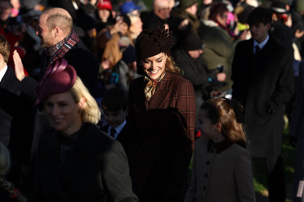 Britain's Catherine, Princess of Wales (C) holds hands with Britain's Prince Louis of Wales (L) and Britain's Princess Charlotte of Wales as they arrive for the Royal Family's traditional Christmas Day service at St Mary Magdalene Church on the Sandringham Estate in eastern England, on December 25, 2025. (Photo by HENRY NICHOLLS / AFP via Getty Images)