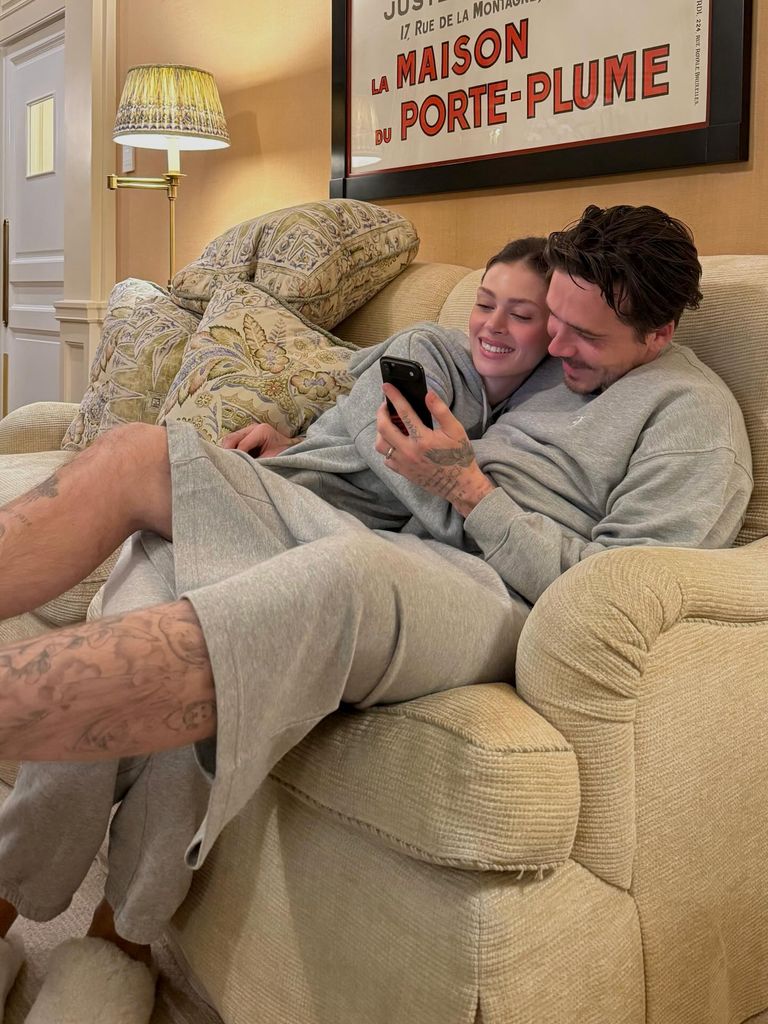 Brooklyn and Nicola cuddling on sofa in grey jogger sets